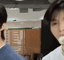 a man in a blue shirt and a woman in a white shirt are standing next to each other in a room