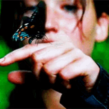a close up of a person holding a butterfly in their hand