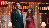 a man and a woman are standing in front of signs that say i love you