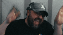 a man with a beard wearing a hat with a white x on it