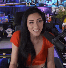 a woman sitting in front of a microphone wearing a red shirt that says pop on it