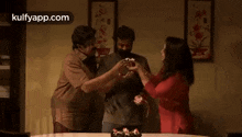 a group of people are standing around a table with a cake in front of them .