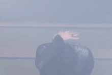 a man in a black leather jacket is dancing on a stage