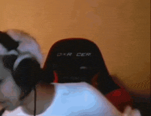 a person wearing headphones sits in a dxr cer gaming chair