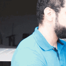 a man with a beard is wearing a blue shirt