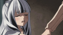 a girl with white hair and black stripes is holding a person 's arm