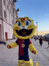 a mascot for a soccer team is standing on a sidewalk