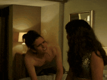 a man without a shirt is standing next to a woman