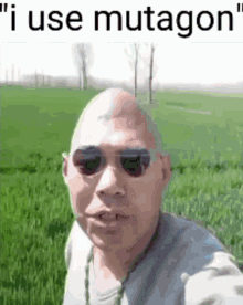 a bald man wearing sunglasses is standing in a grassy field with the words " i use mutagon " above him