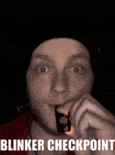 a man is holding a lighter in his mouth and the words blinker checkpoint are visible