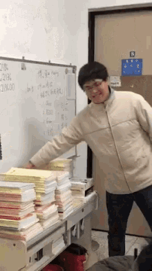 a man is standing in front of a white board with numbers on it and a sign that says b