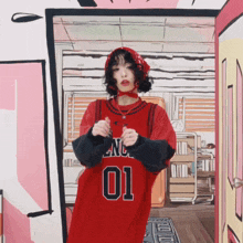 a woman wearing a red lnc 01 jersey