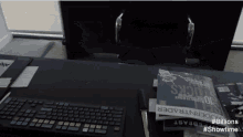 a keyboard sits on a desk next to a stack of books including moderntrader