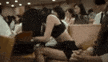 a woman in a bra and shorts is sitting on a chair in a room .