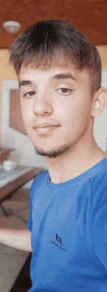 a young man in a blue shirt with the letter b on the front