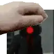 a close up of a person 's hand holding a red light .