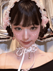 a girl wearing a pink and white headband and a choker with pearls