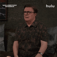 a man wearing glasses and a shirt that says hulu on it