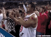 a man wearing a jersey with the number 3 on it is standing in a crowd of people applauding .
