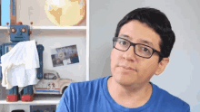 a man wearing glasses stands in front of a herbie the bee toy