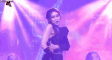 a woman is dancing on a stage in front of a purple light .