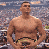 a shirtless wrestler stands in front of a crowd at a wrestlemania