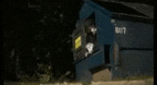 a person is standing in front of a dumpster with the number 807 on it