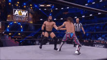 two men are wrestling in a ring with a sign that says aew wrestling dark in the background
