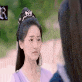 a woman in a purple dress looks at another woman in a blue shirt