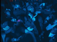 a group of people dancing in a dark room with a blue background