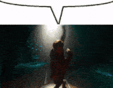 a person standing in a dark room with a speech bubble above them