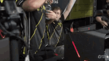 a man holding a bottle of water in front of a sign that says ' titan force '