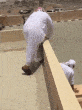 a man in a white robe is standing on a wall