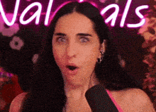 a woman with a surprised look on her face is standing in front of a neon sign that says naturals