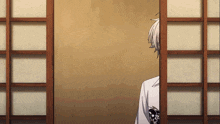 a man in a white shirt is peeking out from behind a wooden sliding glass door
