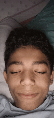 a young boy with his eyes closed is wearing a shirt that says ' ec ' on it