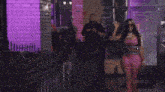 a woman in a pink dolce gabbana outfit stands in a restaurant