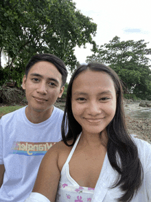 a man and a woman are posing for a picture and the woman is wearing a shirt that says island