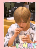 a young man drinking from a starbucks cup with the word yummy on it