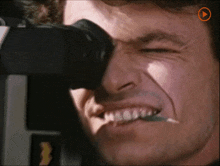 a close up of a man looking through a telescope