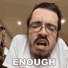 a man with glasses and a beard is making a funny face with the word enough written on his face