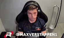 a man wearing headphones is sitting in a chair and looking at the camera .