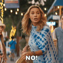a woman wearing a blue and white tie dye top says no