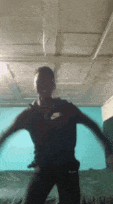 a man in a nike jacket is dancing in a room with a blue wall .