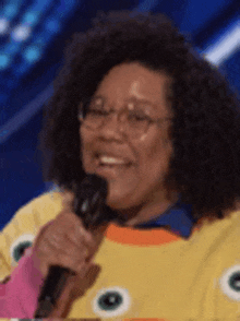 a woman is holding a microphone and smiling .