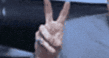 a person giving a peace sign with their fingers