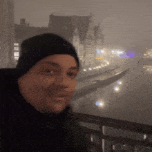 a man in a black hat stands in front of a foggy river