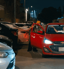a red chevrolet car with a license plate that says 5772