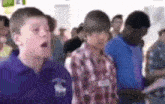 a group of young boys are standing in a line in a room .