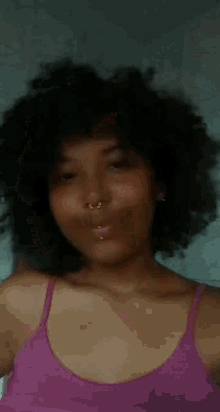 a woman in a purple tank top is making a funny face
